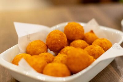Appetizing golden cheese balls served on a white platter, perfect for snacking.