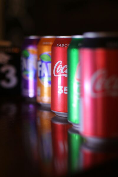 Close-up of vibrant soft drink cans lined up with selective focus.